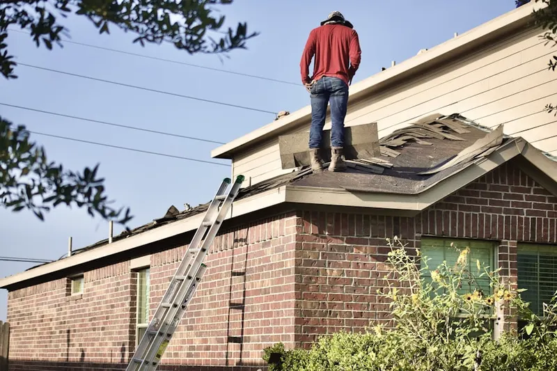 Professional roofer working on a residential roof in Highland View